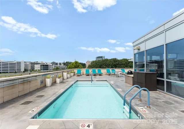 a swimming pool with outdoor seating and barbeque oven