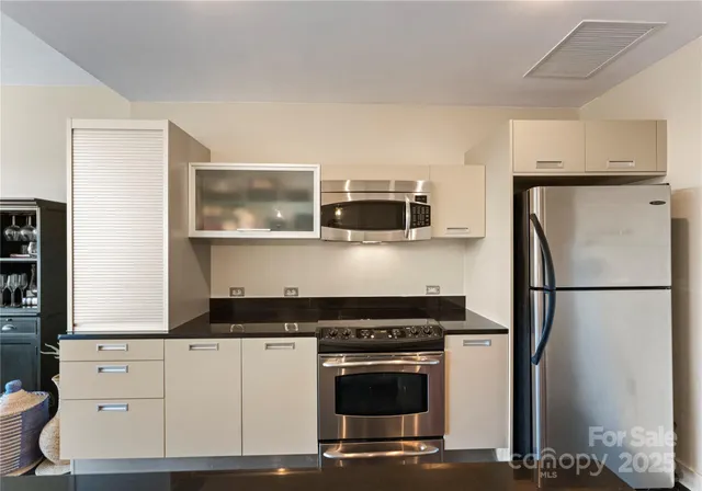 a kitchen with stainless steel appliances a refrigerator stove and microwave