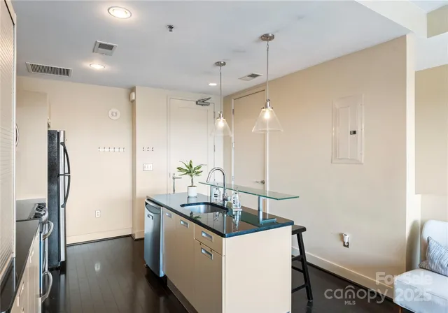 a kitchen that has a sink a toilet and a refrigerator