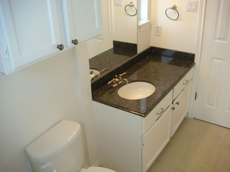 4000 Rawlins Street, Unit 105 Dallas, TX 75219 - Photo 20 of 26 a bathroom with a granite countertop sink and a mirror