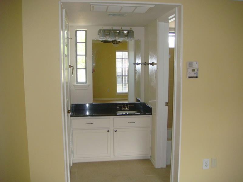 4000 Rawlins Street, Unit 105 Dallas, TX 75219 - Photo 23 of 26 a bathroom with a granite countertop sink and a mirror