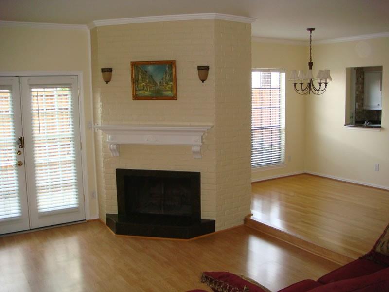 4000 Rawlins Street, Unit 105 Dallas, TX 75219 - Photo 6 of 26 a view of an empty room with wooden floor and a fireplace