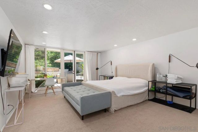 a bedroom with a bed and large window