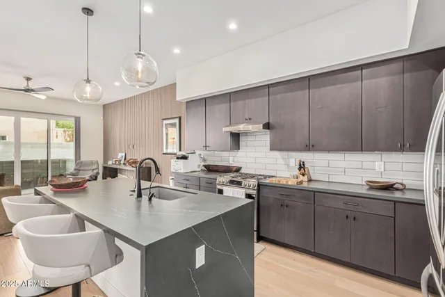 a kitchen with a sink a counter space appliances and cabinets