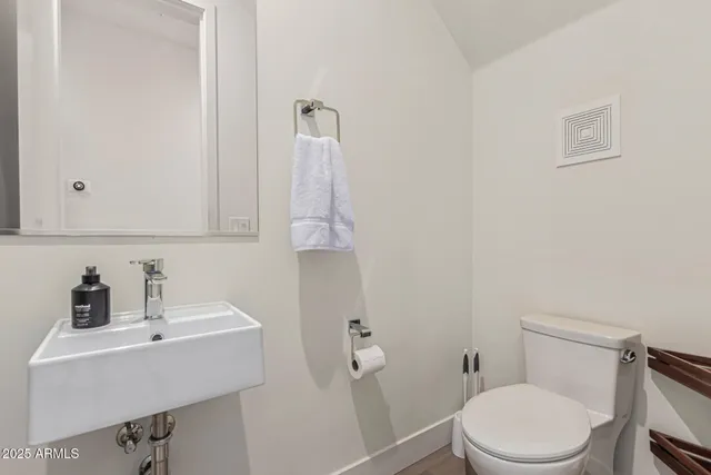 a bathroom with a sink a toilet and mirror