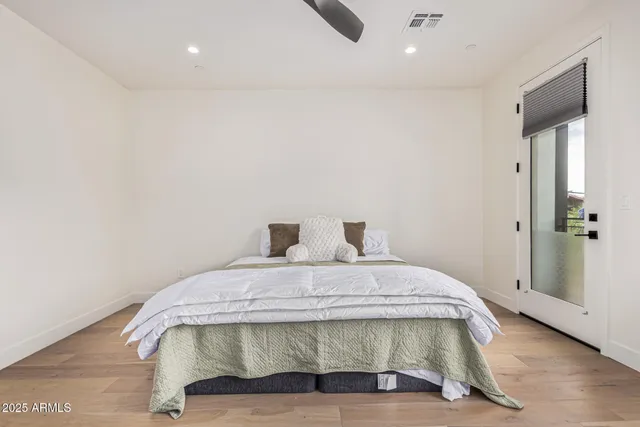 a bedroom with a bed and wooden floor