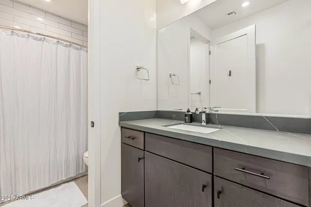a bathroom with a granite countertop sink and a mirror