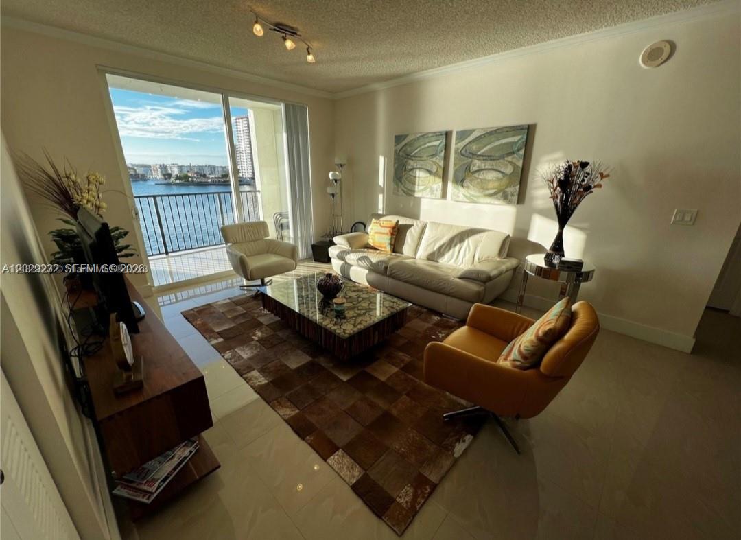17100 North Bay Road, Unit 1605 Sunny Isles Beach, FL 33160 - Photo 9 of 52 a living room with furniture and a flat screen tv