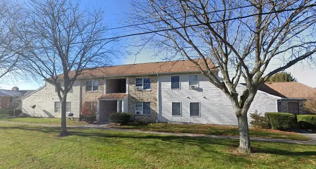 a front view of a house with a yard garden and tree