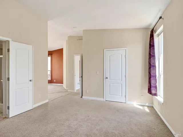 an empty room that has a window and a mirror