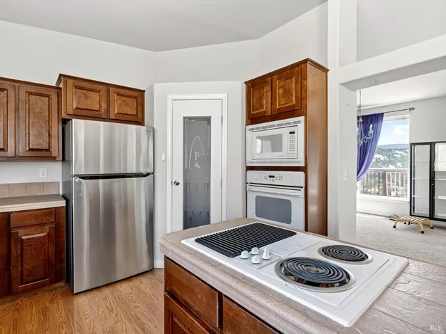 a kitchen with kitchen island a large window sink and cabinets