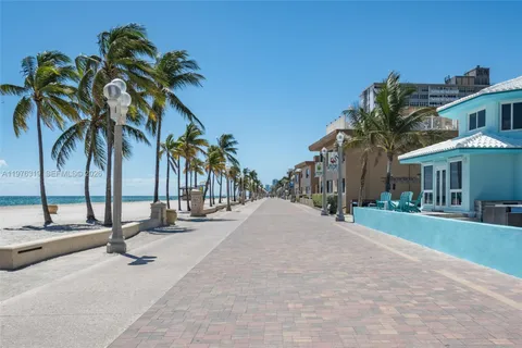 a row of palm trees in front of house