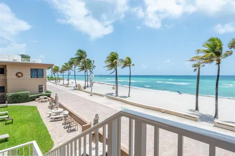 a view of a backyard with couches under an umbrella