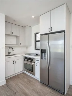 a kitchen with a refrigerator sink and cabinets