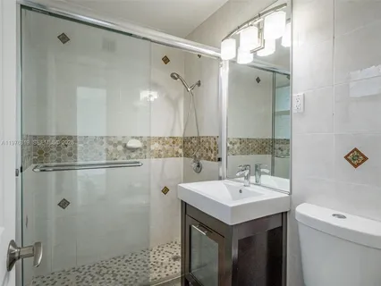 a bathroom with a sink mirror and a shower