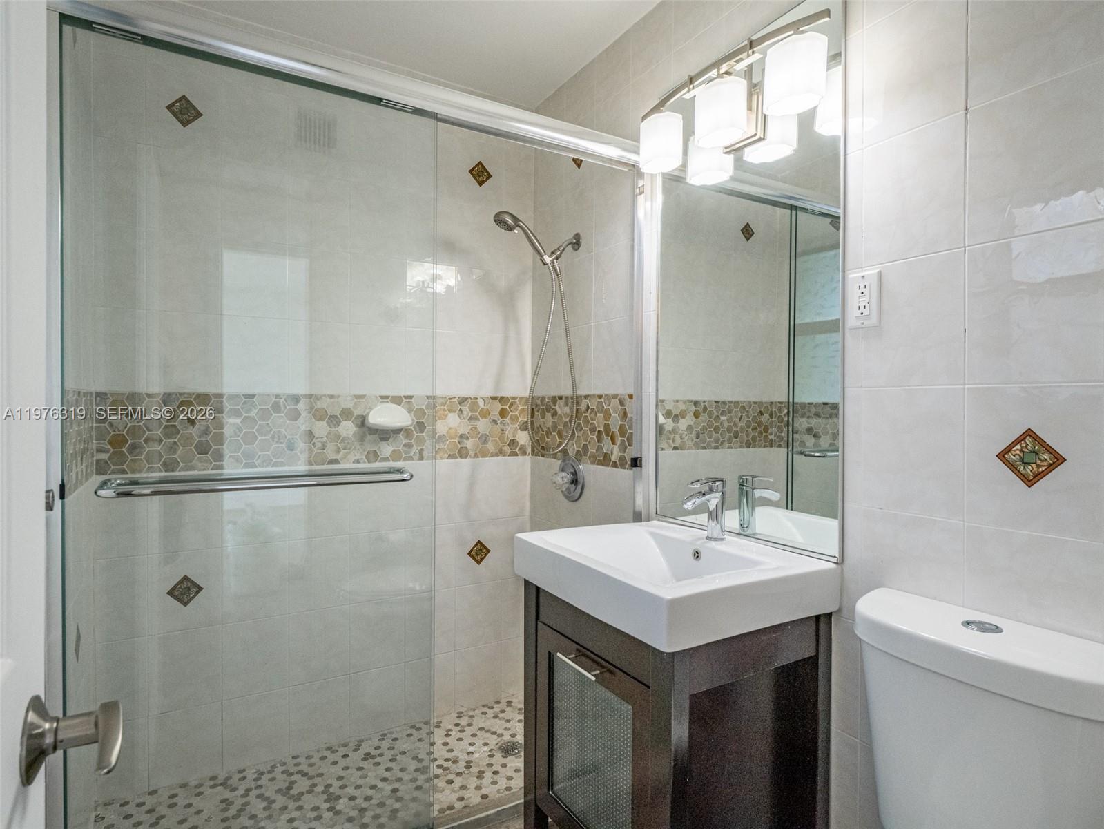 3300 North Surf Road, Unit 26A Hollywood, FL 33019 - Photo 7 of 19 a bathroom with a sink mirror and a shower
