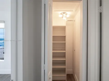 a view of walk in closet with empty racks