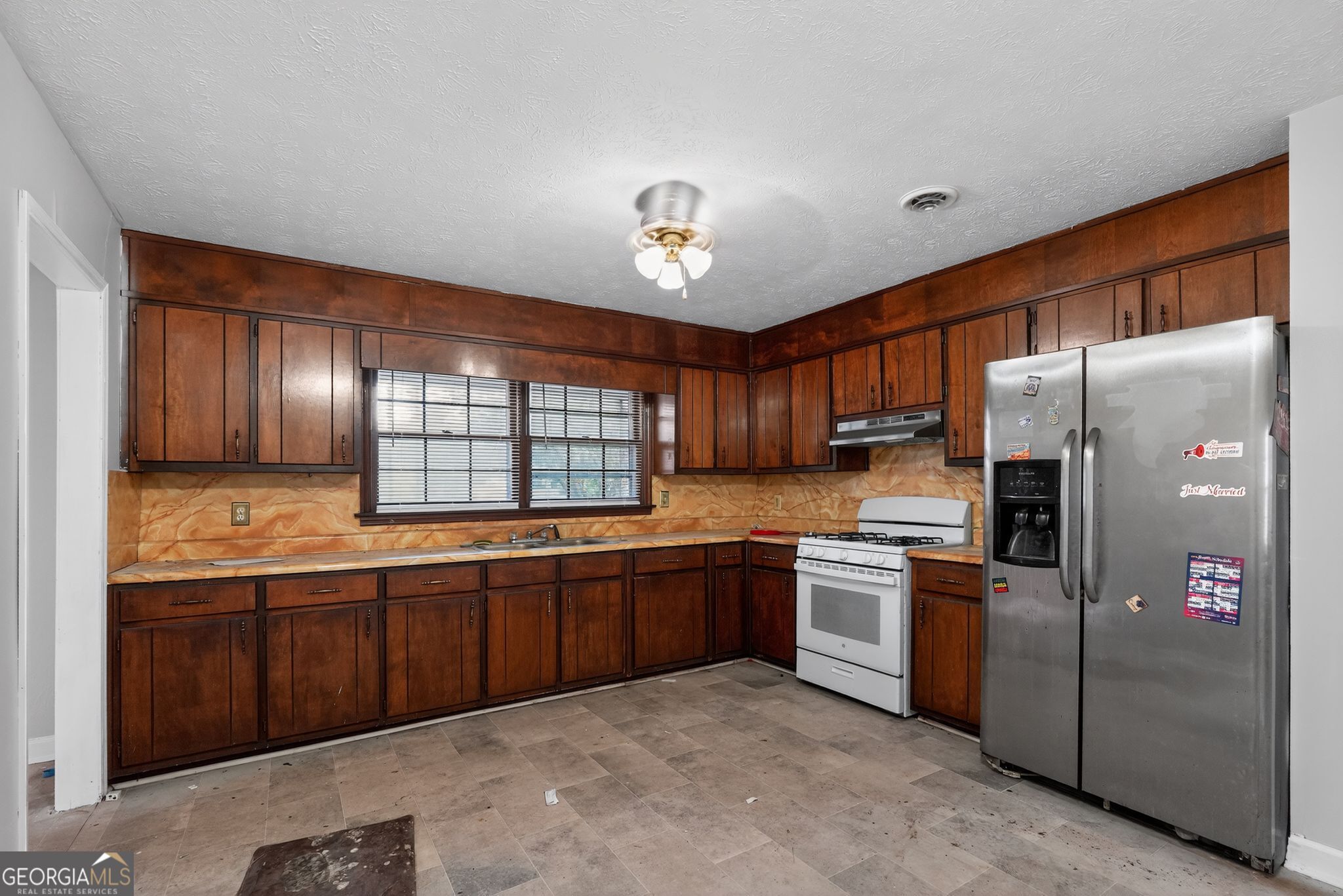 2653 Lester Street Atlanta, GA 30344 - Photo 12 of 34 a kitchen with stainless steel appliances granite countertop a refrigerator a sink dishwasher a stove and a refrigerator with wooden cabinets