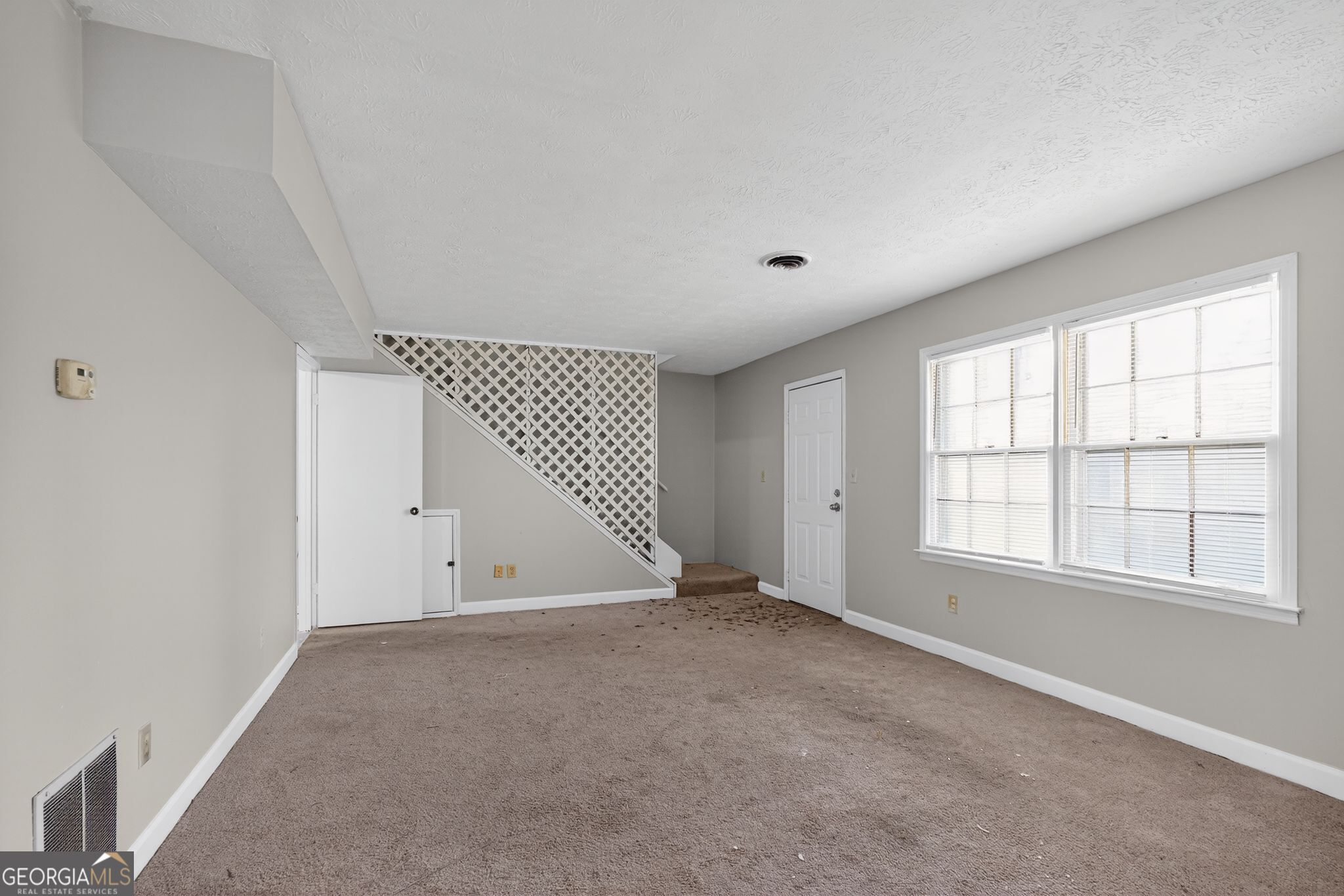2653 Lester Street Atlanta, GA 30344 - Photo 7 of 34 an empty room with wooden floor and windows