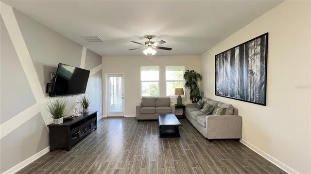 a living room with furniture a flat screen tv and kitchen view