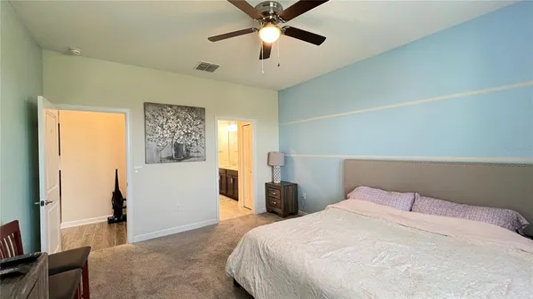 a bedroom with a bed and a flat tv screen on the dresser