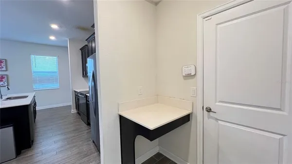 a view of a workspace with furniture and a window