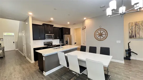 a large kitchen with stainless steel appliances a large counter top space cabinets and furniture