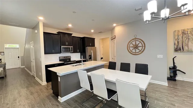 a large kitchen with stainless steel appliances a large counter top space cabinets and furniture