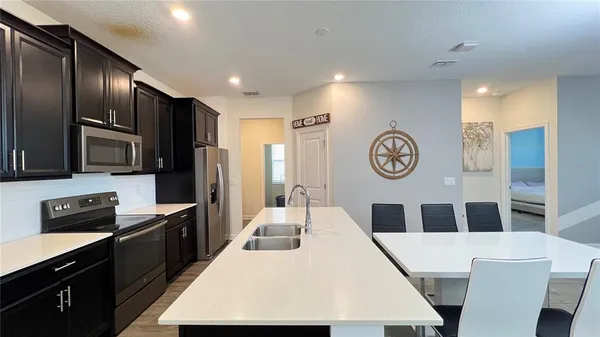 a kitchen with a table chairs and a clock on the wall