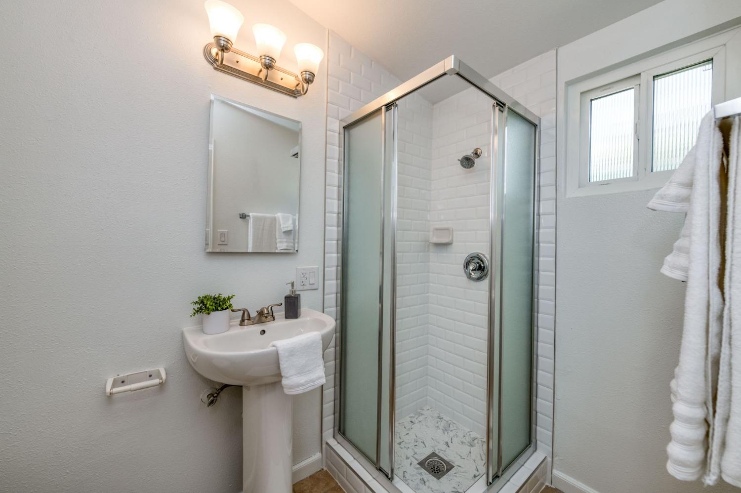2607 Crescent Avenue Clovis, CA 93612 - Photo 19 of 26 a bathroom with a sink a mirror and shower