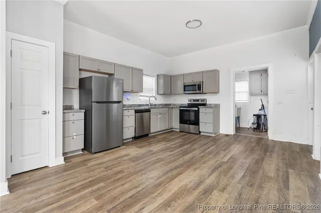 a view of kitchen with stainless steel appliances granite countertop a stove top oven a refrigerator and a sink