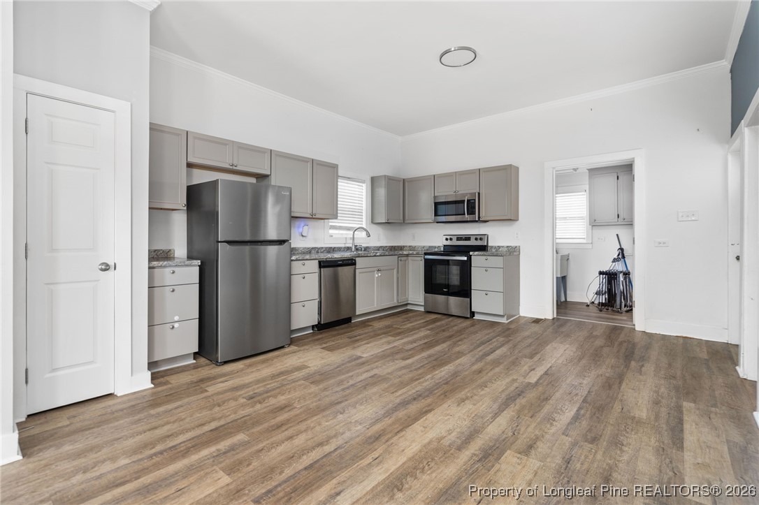 107 North 12th Street Erwin, NC 28339 - Photo 8 of 40 a view of kitchen with stainless steel appliances granite countertop a stove top oven a refrigerator and a sink