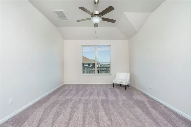 an empty room with windows and ceiling fan