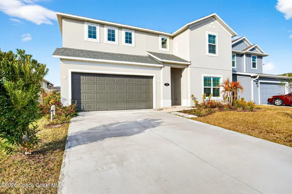 a front view of a house with a yard and garage