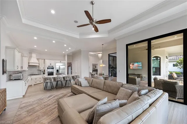 a living room with furniture kitchen view and a wooden floor