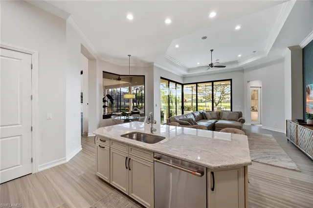 a kitchen with granite countertop a sink and white cabinets with wooden floor