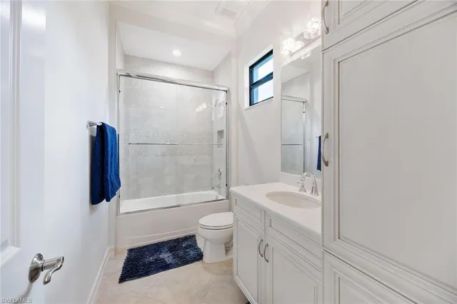 a bathroom with a granite countertop shower sink vanity mirror and toilet