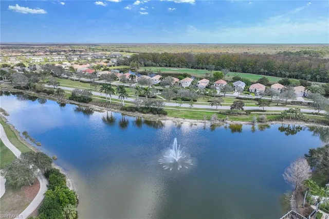 an aerial view of residential houses with outdoor space and lake view