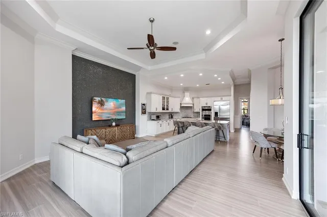 a living room with stainless steel appliances kitchen island furniture a flat screen tv and a kitchen view