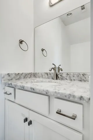 a bathroom with a granite countertop sink and mirror