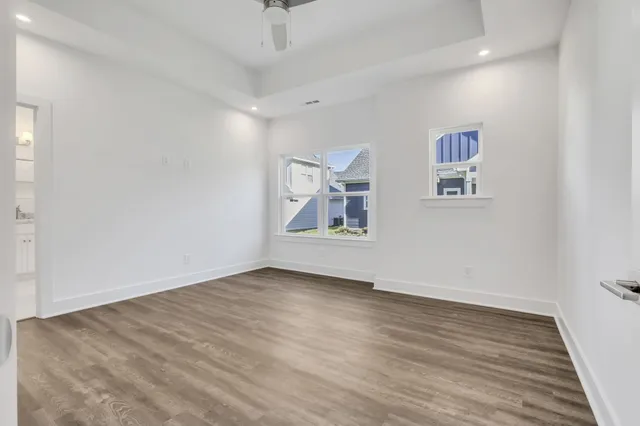 an empty room with wooden floor and window