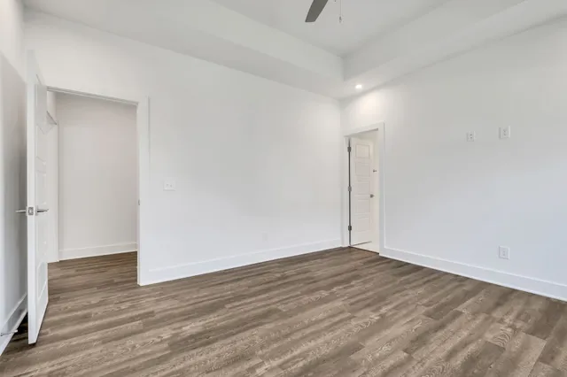 a view of an empty room with wooden floor
