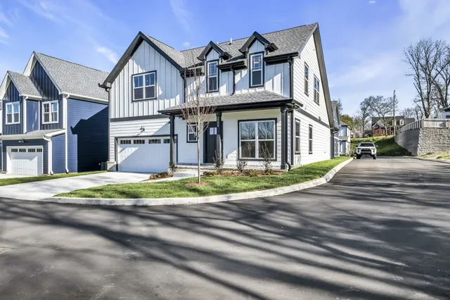 a view of a white house with a small yard and plants