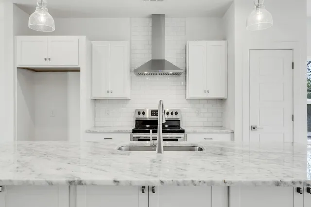 a kitchen with granite countertop a stove a sink and a granite counter tops