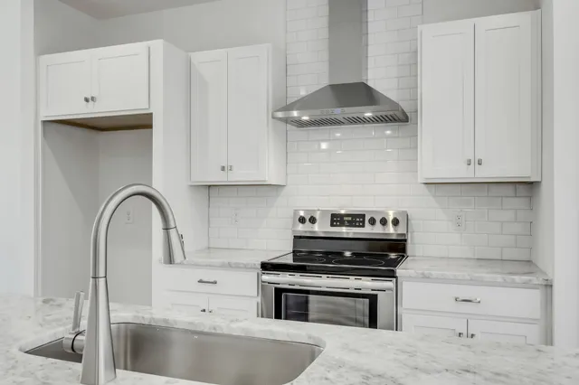 a kitchen with granite countertop a stove and a sink