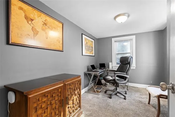 a view of a workspace with furniture and a window