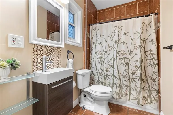 a bathroom with a toilet a sink and a shower curtain