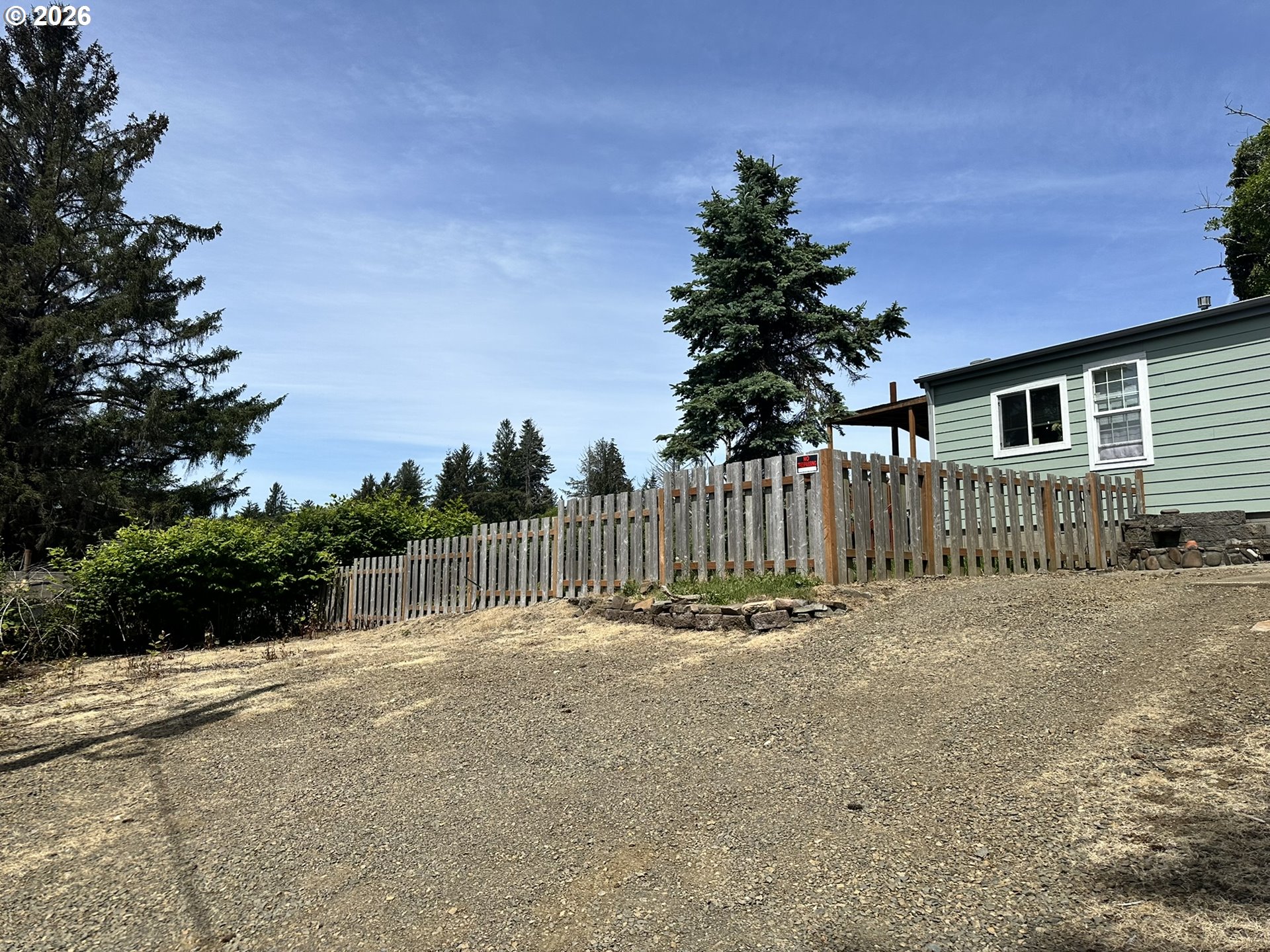 4821 Northeast 50th Street Neotsu, OR 97364 - Photo 15 of 19 a view of a backyard with plants and wooden fence