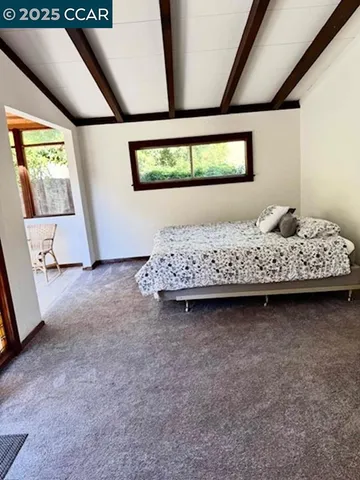 a bed sitting in a bedroom next to a window