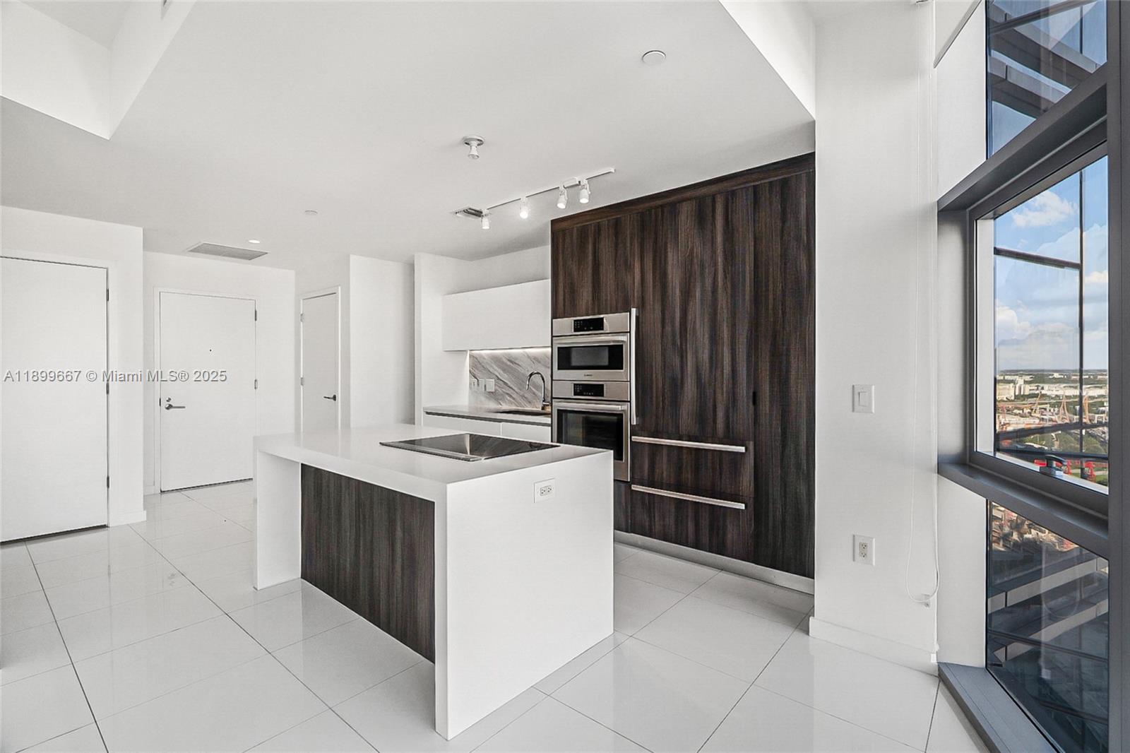 851 Northeast 1st Avenue, Unit 2802 Miami, FL 33132 - Photo 5 of 59 a kitchen with stainless steel appliances granite countertop a refrigerator and a stove top oven